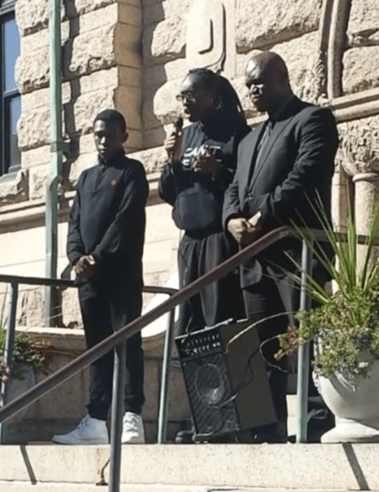 Anye Nkimbeng (left) listens to fellow classmate Amy Boateng and Family Lawyer Ahanna Igwe address the crowd